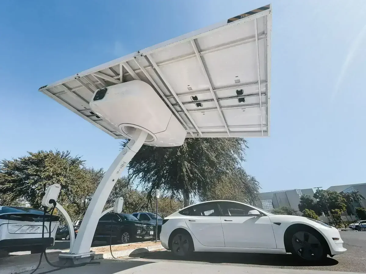 Estação de carregamento solar para veículos elétricos, com painel fotovoltaico e carro branco conectado